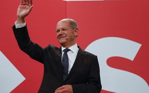 SPD leader Olaf Scholz greeting celebrating party members Sunday evening.