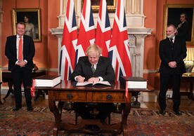 British Prime Minister Boris Johnson signing the UK-EU Trade and Cooperation Agreement as Lord David Frost, UK chief negotiator, and Sir Tim Barrow, UK ambassador to the EU, look on, December 30.